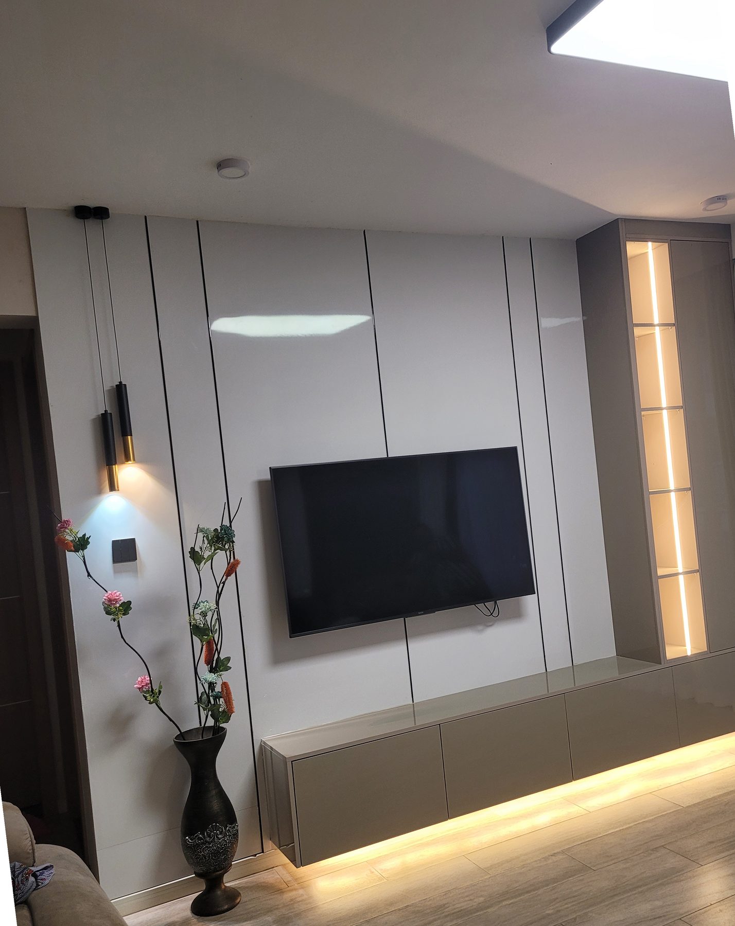 TV wall unit in fluted panelling with an illuminated glass display cabinet